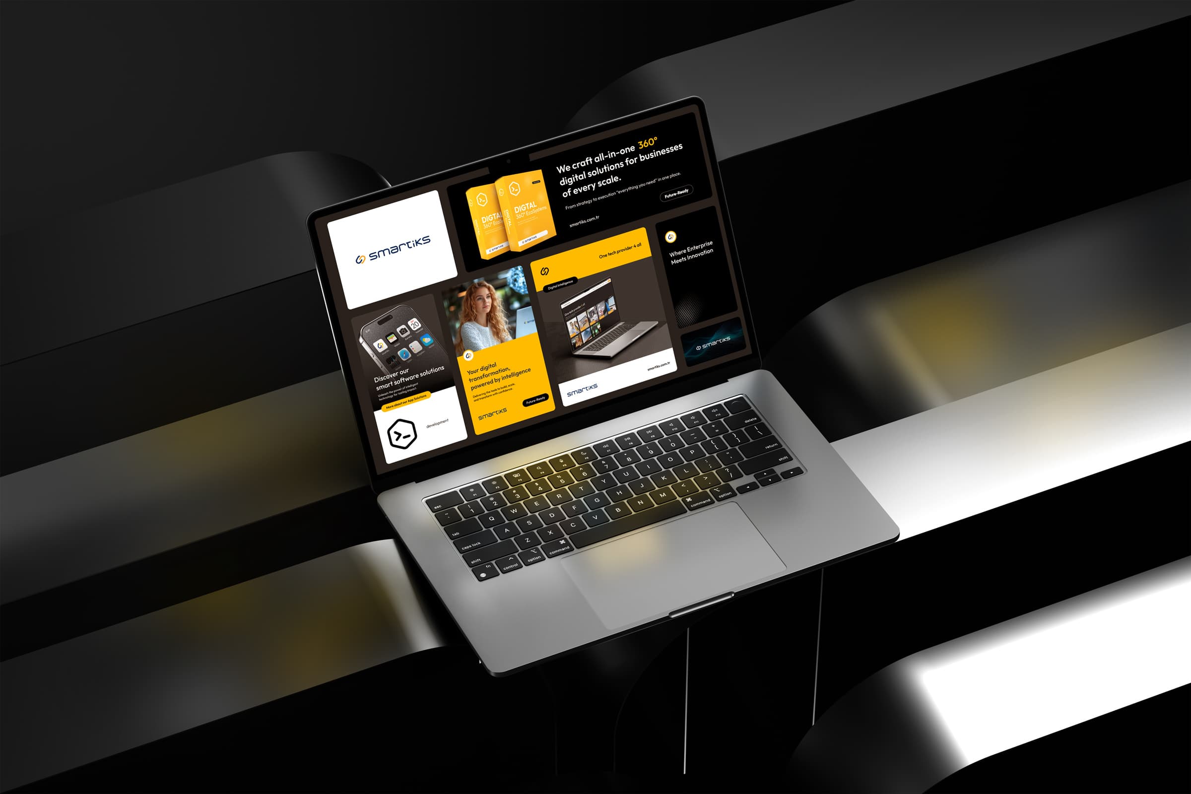 A MacBook on a dark stage showing the Smartiks brand system as a grid of components, including the logo, the line we craft all-in-one 360 degree digital solutions and packaging for digital ecosystems