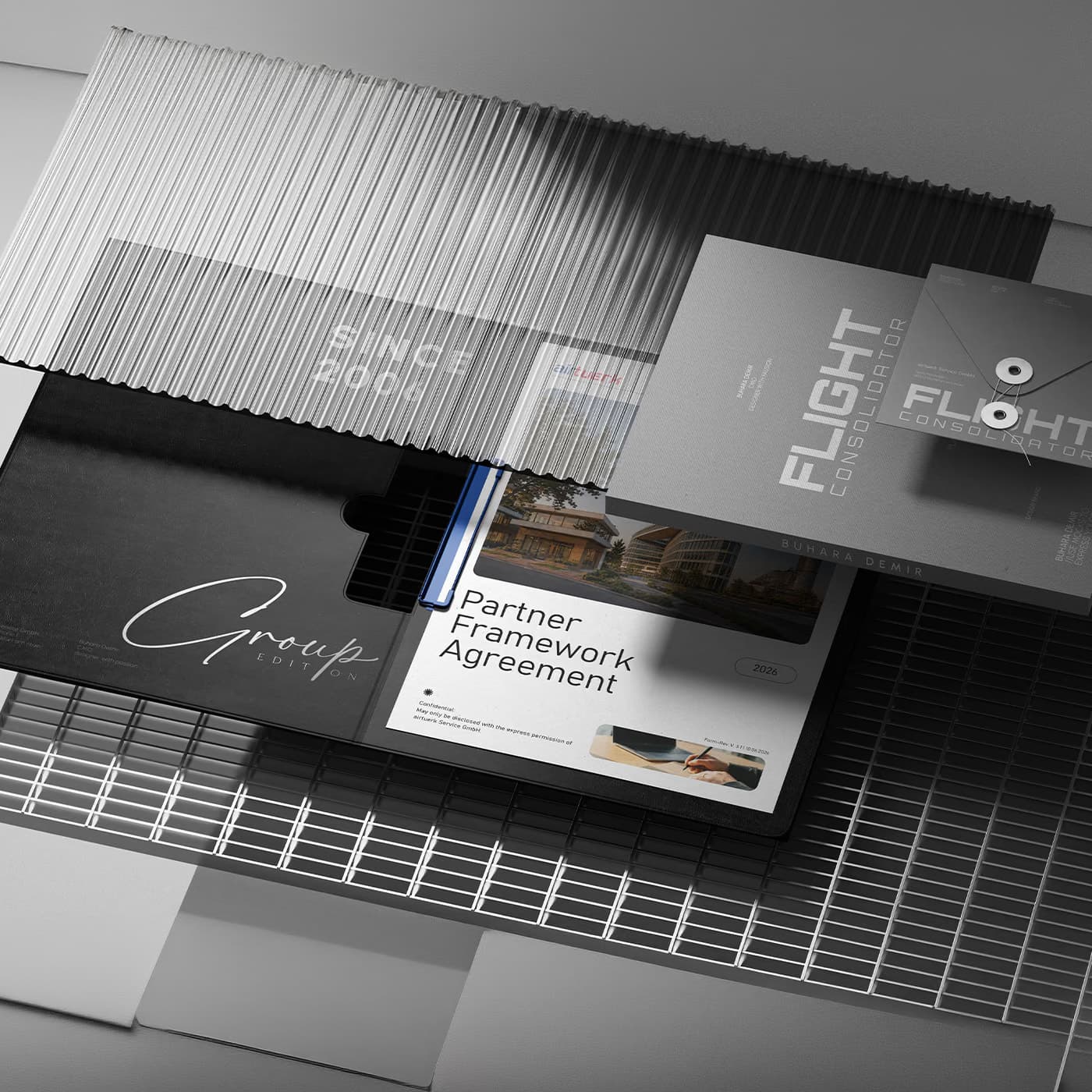 A dark stationery arrangement photographed at an angle, showing the black Group Edition folder, a Partner Framework Agreement dated 2026 marked confidential, and a grey Flight Consolidator cover printed with the name Buhara Demir
